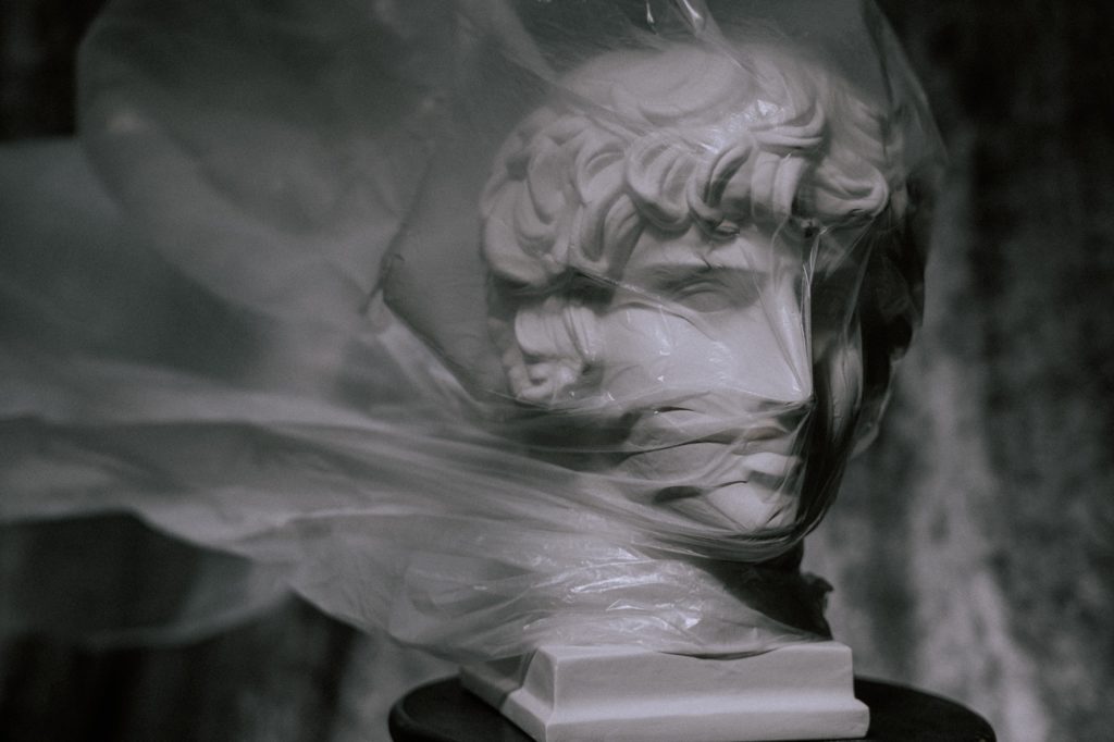 Photo of sculpture being suffocated by a plastic bag