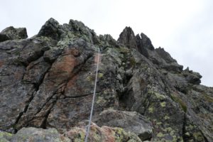 Photo of a granite rock wall with a climbing rope